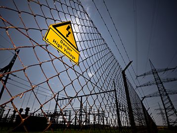 High voltage electric fence with warning sign