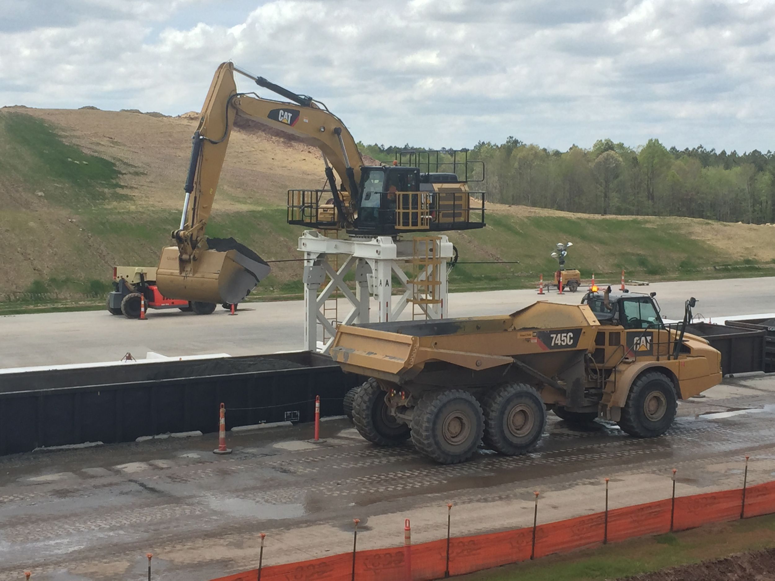 Charah uses special Cat® 336 excavators on straddle carriers and Cat 745 trucks to load and haul ash.