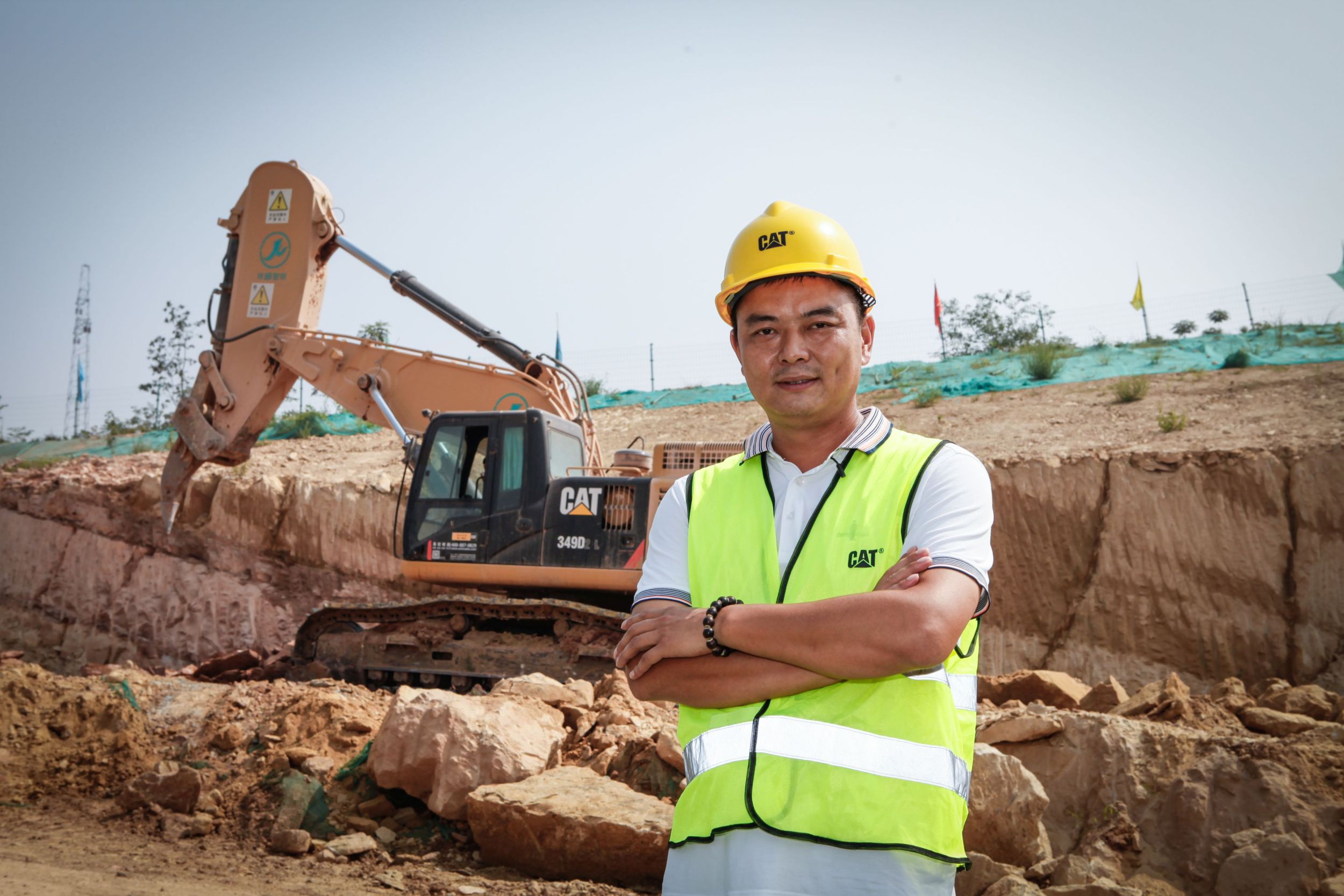 Chen Hu, owner of Sanhe Rental, stands in front of one of his frontless hydraulic excavators purchased through Caterpillar OEM Solutions, fitted with a rock arm and ripper for a special application.