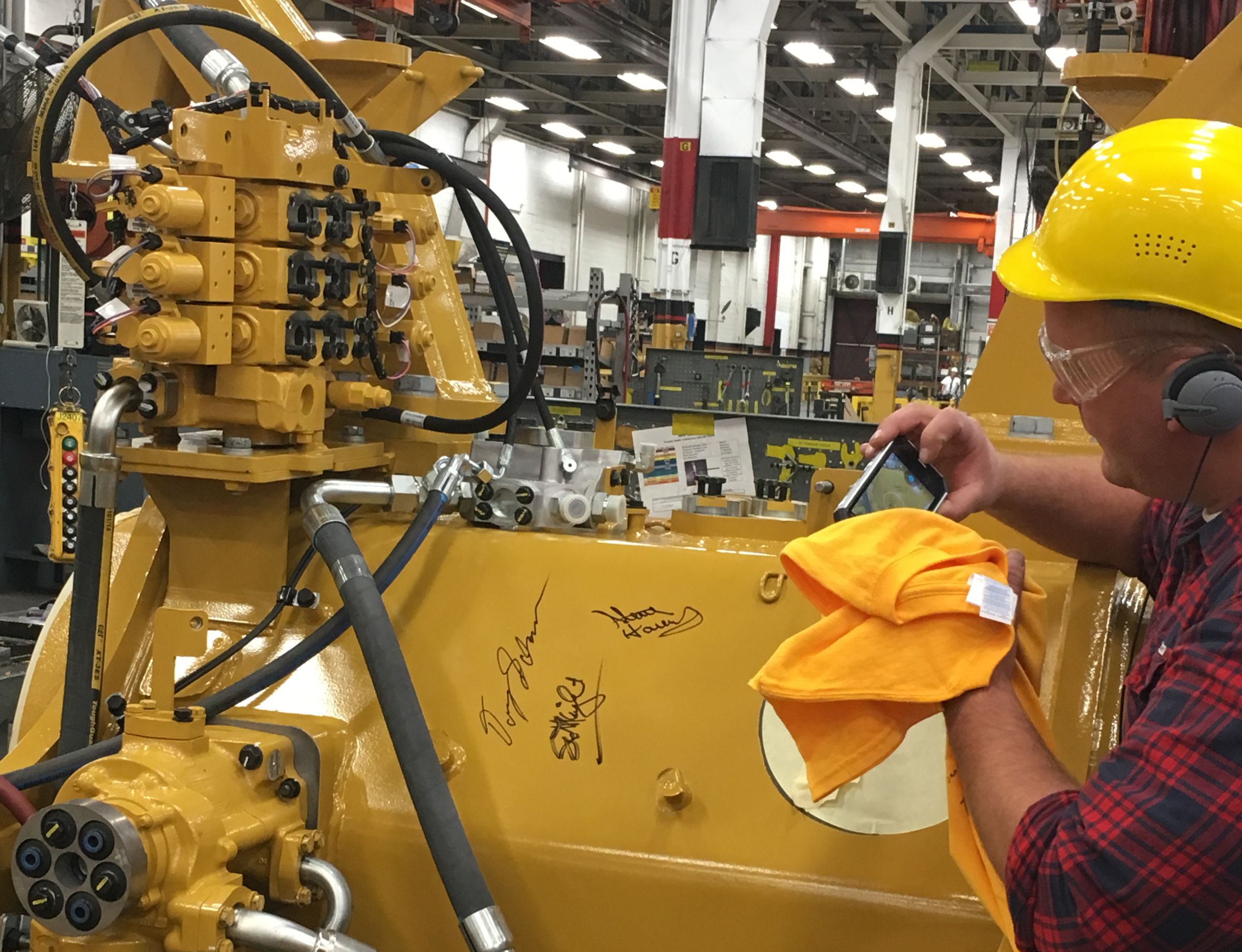 PDC employee Doug Schaub captures the moment by taking a photo of the signatures on the machine. 