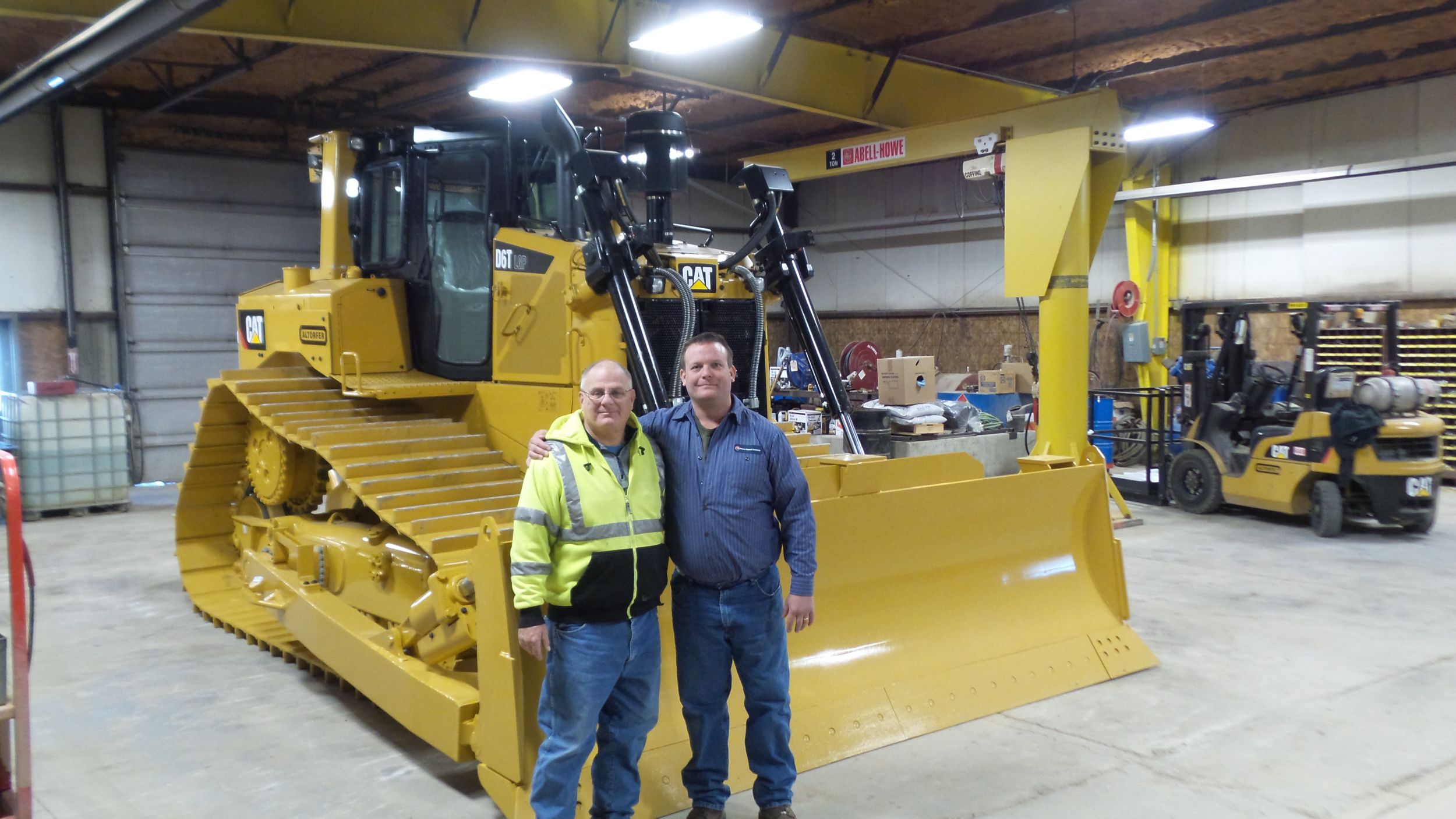 Steve Harenberg and Doug Schaub pose next to the recently-delivered new Cat® D6T LGP. 