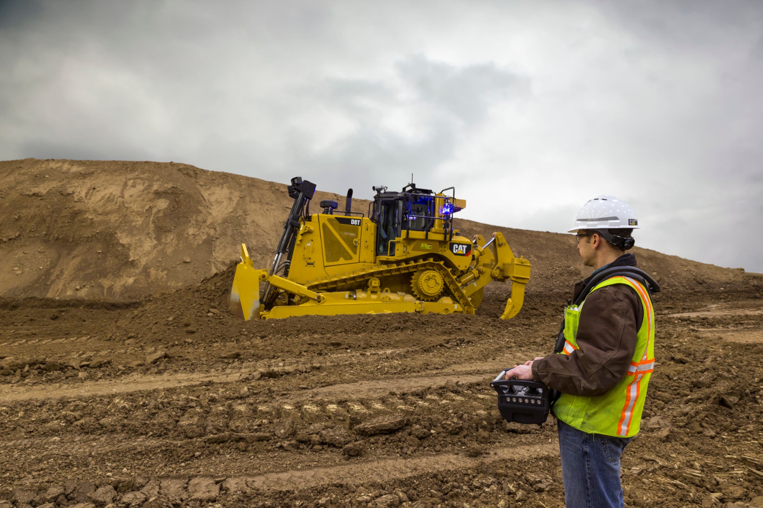 With Cat® COMMAND, the machine is controlled from outside the cab. The operator is out of harm’s way using an over-the-shoulder operator console.