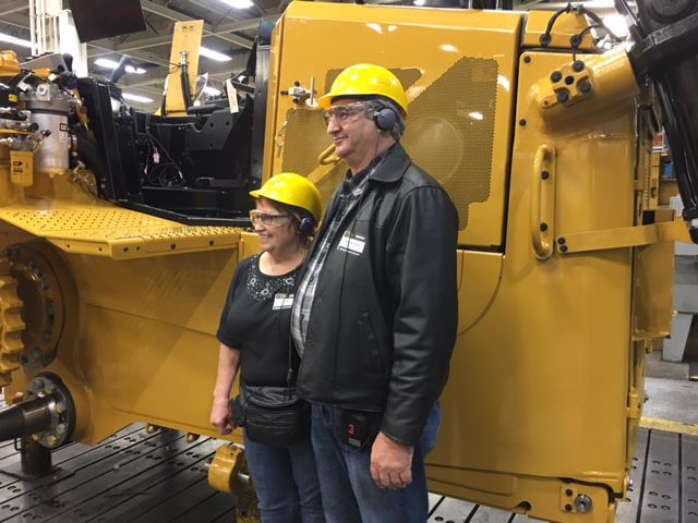 Alice and Phil McClain of McClain Construction visited facilities around Peoria, Illinois, to see what went into building their new D6T dozer. They stopped for a picture next to their unfinished machine in Building SS in East Peoria, Illinois.