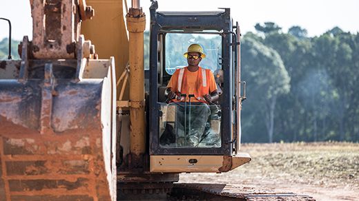 Cliente operando uma escavadeira no local de trabalho