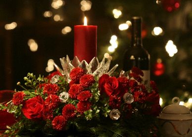 Red roses, carnations, cedar, pine, oregonia and holly holiday flower arrangement