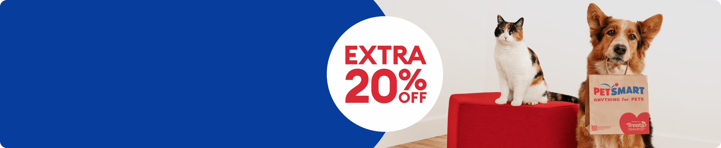 Cat sitting beside a dog holding a PetSmart shopping bag with an extra 20% off, today only badge