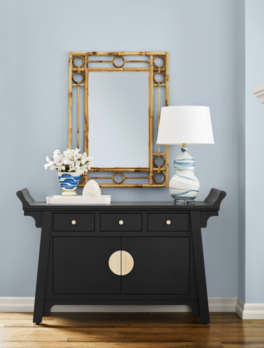 Entryway painted in Upward with a black dresser and minimal decor;Dining room walls in upward with wicker chairs, fireplace, window double doors, and decor; entryway walls in upwars with a wooden side table with decor; bathroom cabinets in upward with white walls, small weaved hamper, and mirrors.