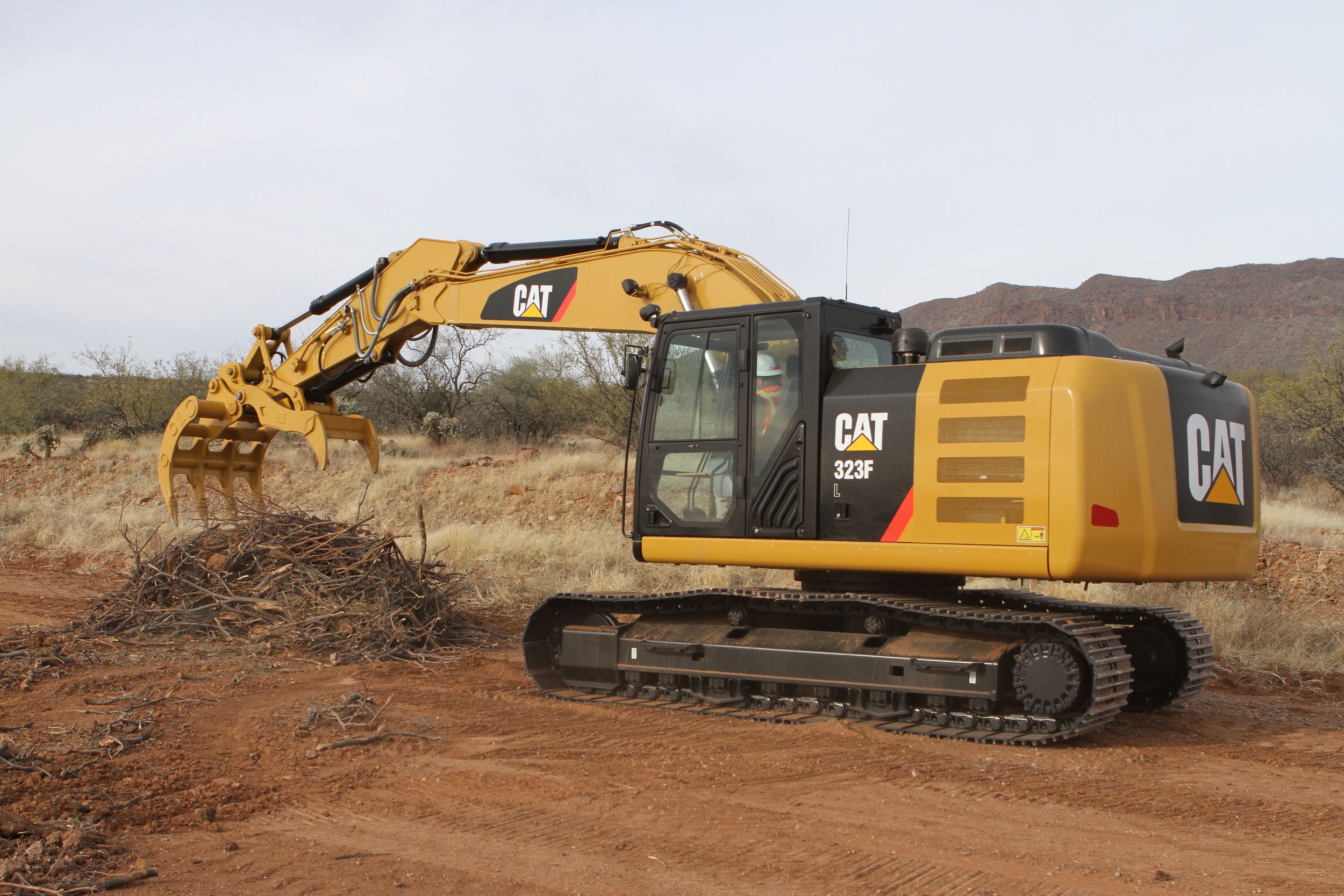 Excavator Rake and Pro Series Thumb working together for site clean-up.
