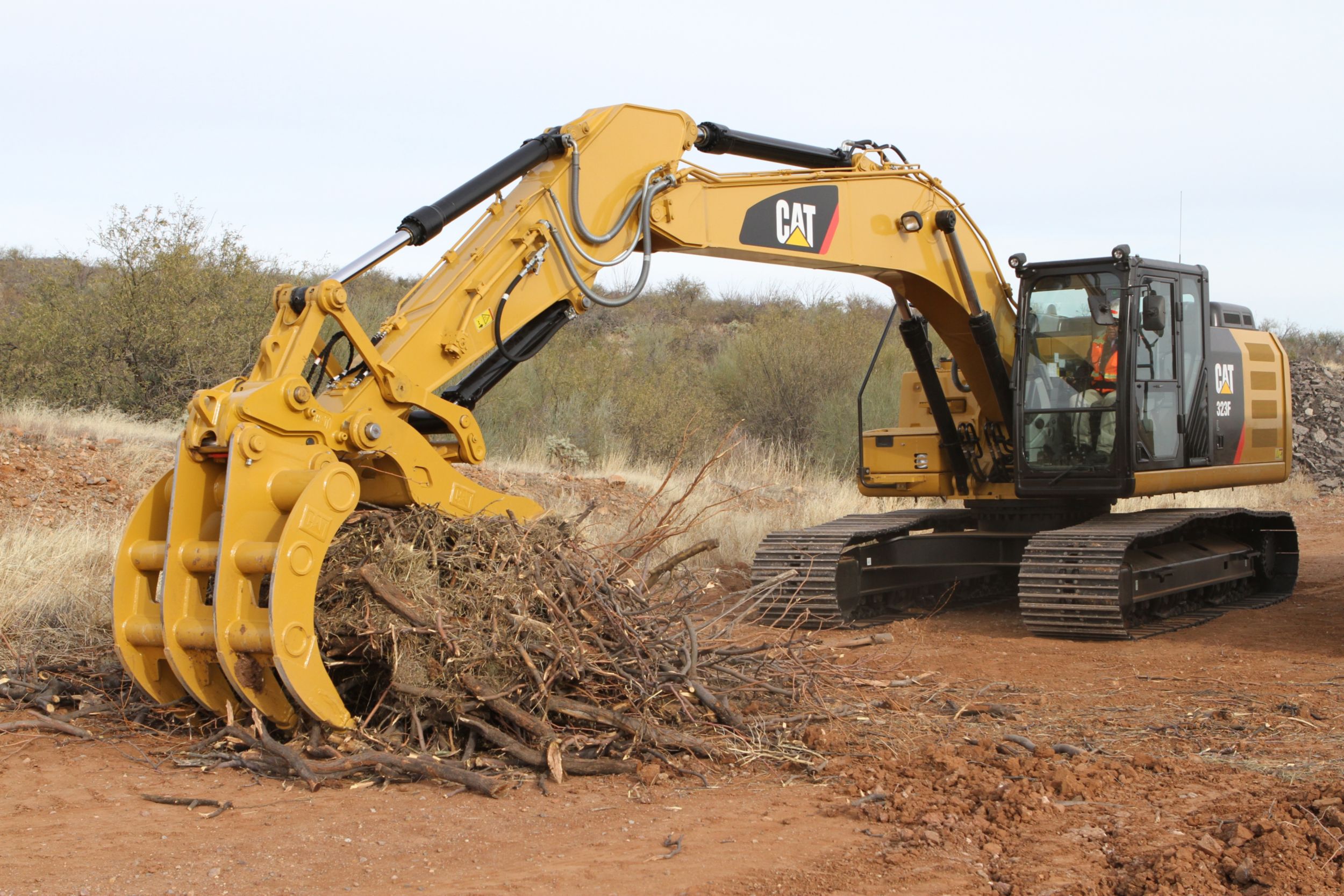 Excavator Rake and Pro Series Thumb working together to handle brush.