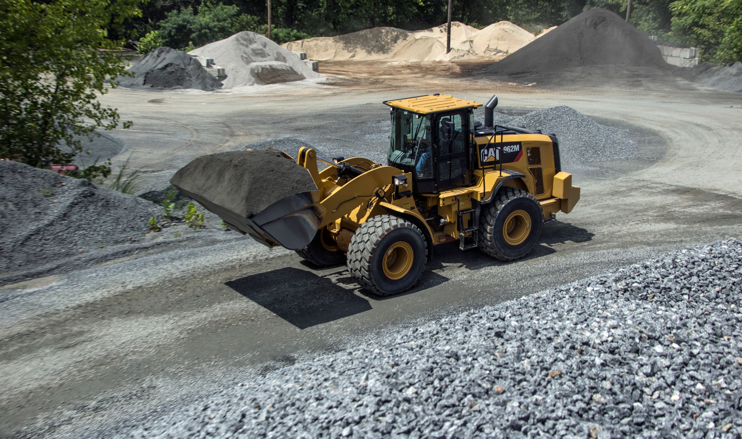 Średnia ładowarka kołowa 962M transportująca ładunek materiału