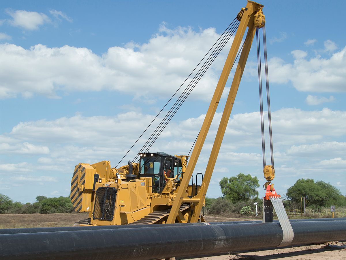 Tracteur pose-canalisations PL83 transportant une canalisation