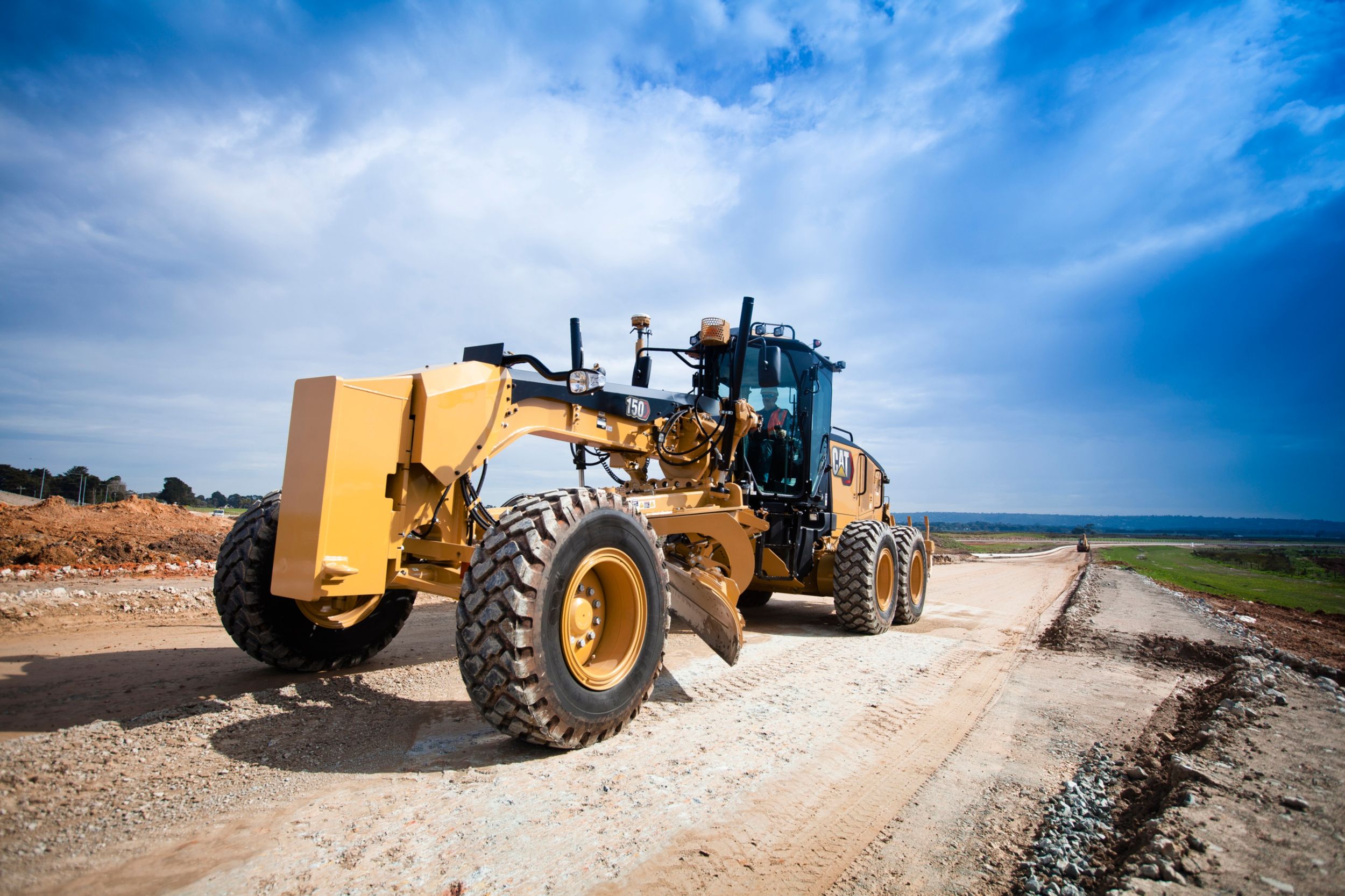 140 Motor Grader spreading rock on roads