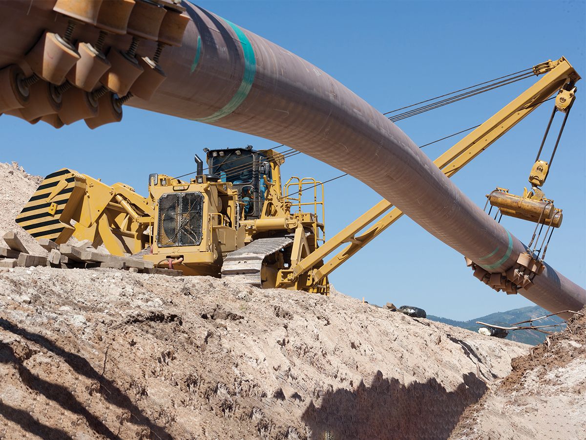 PL87 Pipelayer precisely lowering pipe into the trench