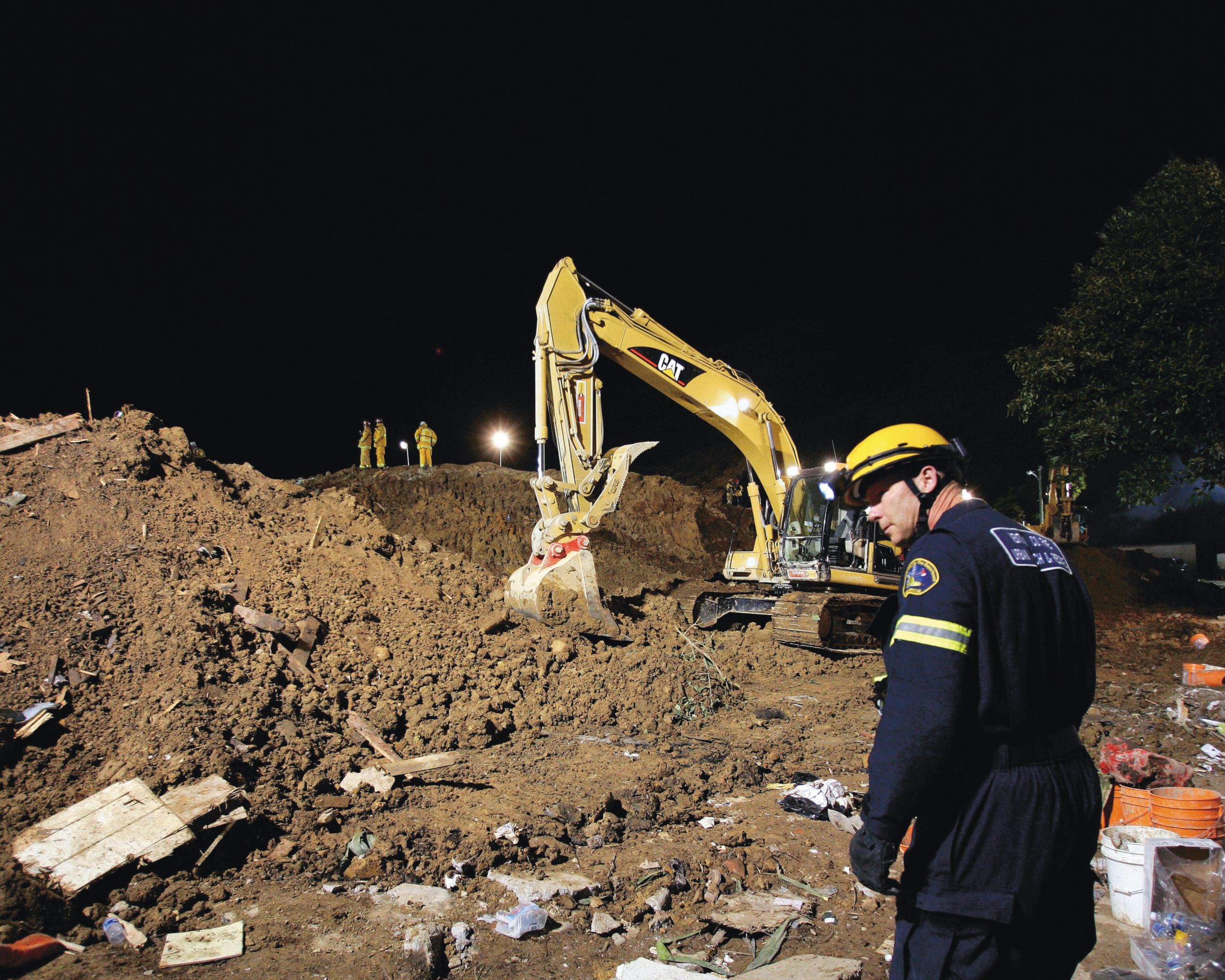 地震と津波の後片付け作業を行うCAT油圧ショベル