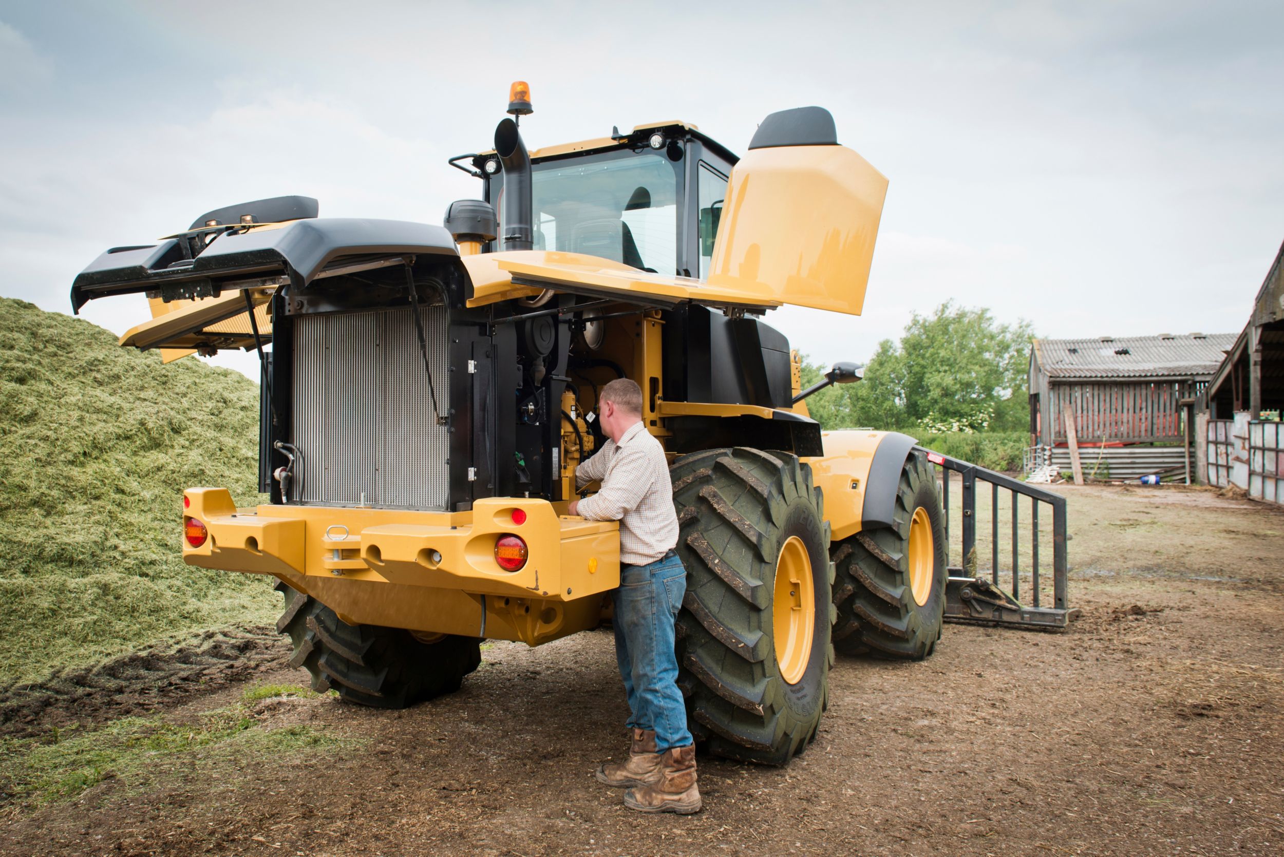 person performing maintenance on a small wheel loader