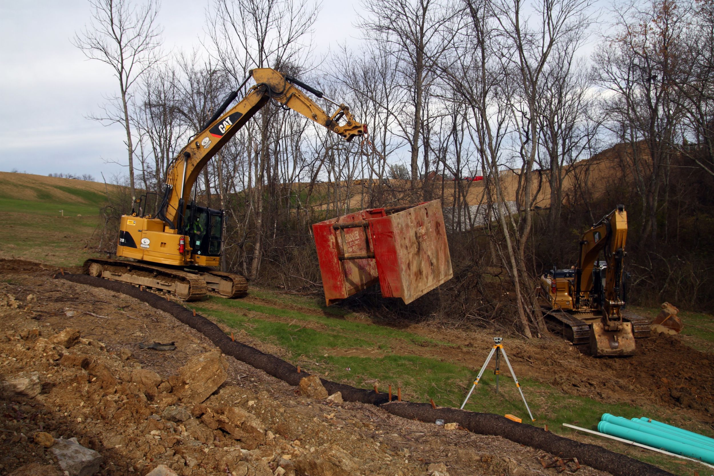 Site clean-up with coupler, bucket and thumb.