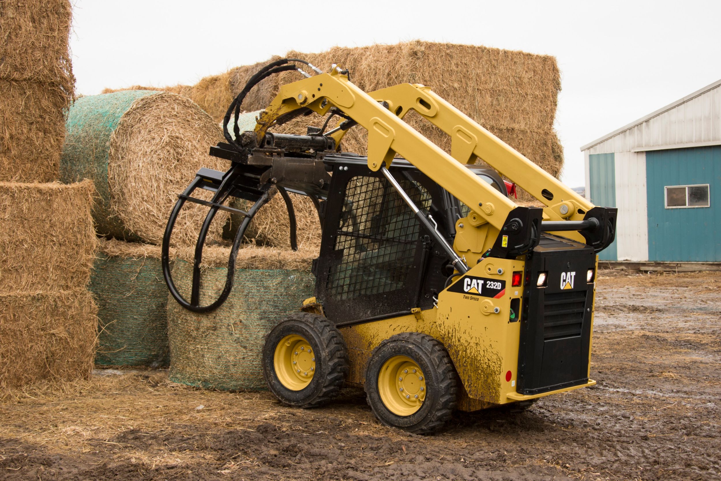 Cat® balengrijper die een gewikkelde baal opraapt