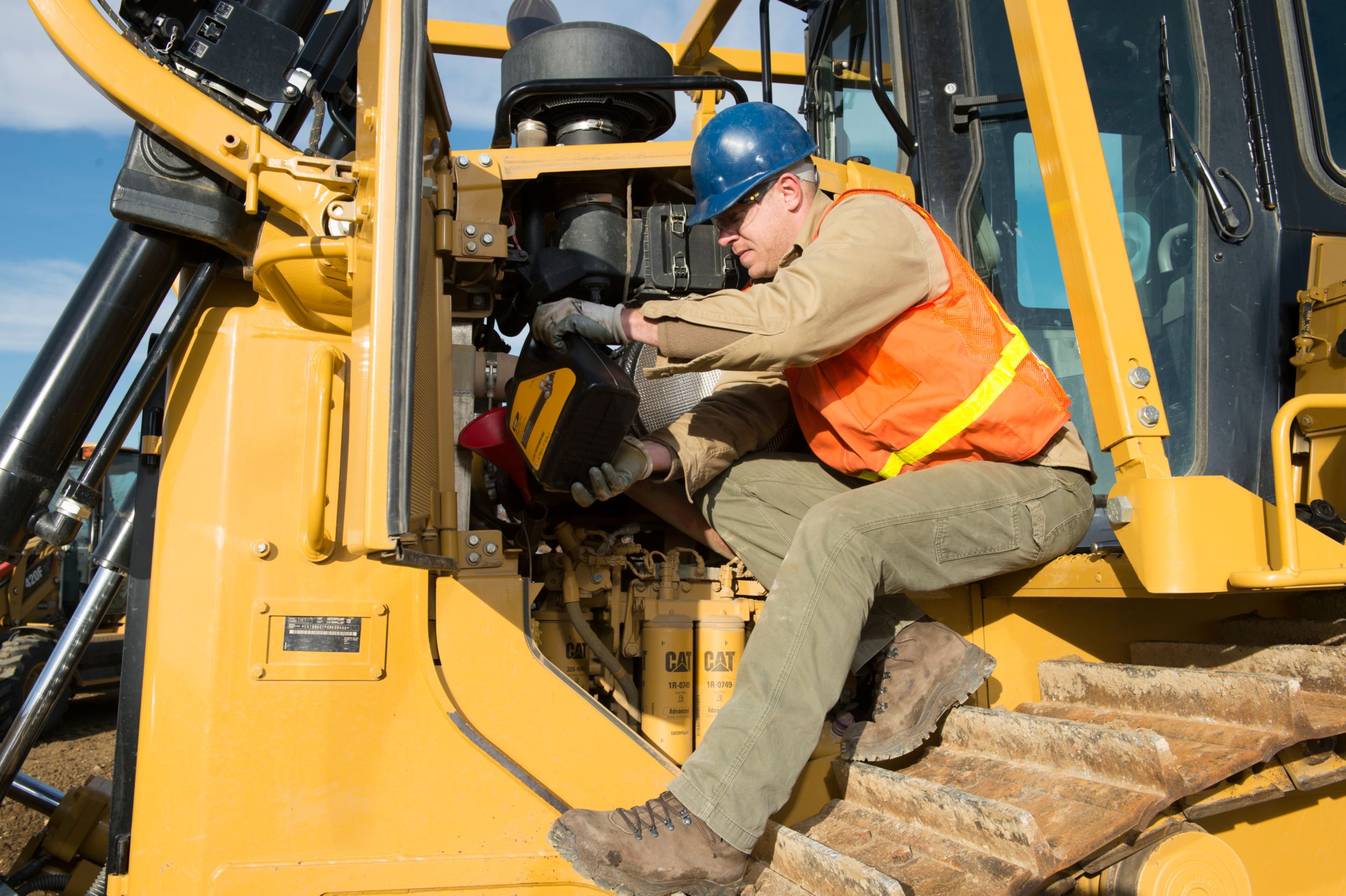 pelanggan mengganti oli di alat beratnya