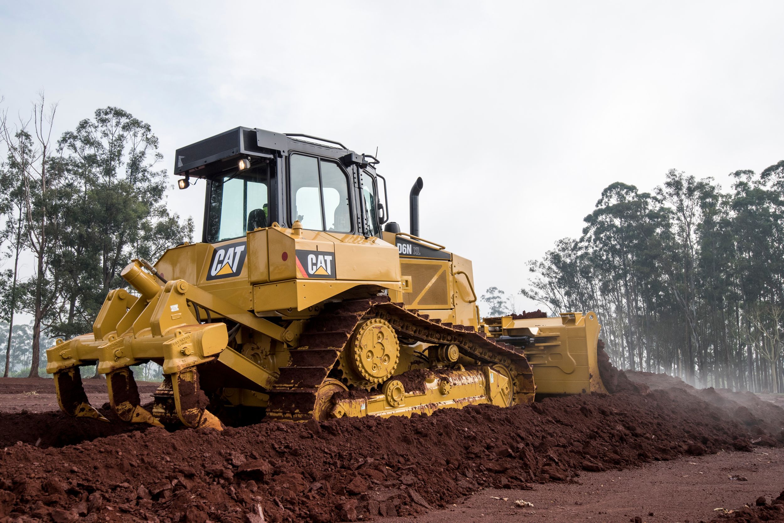 Cat D6N XL Dozer pushing dirt with a ripper system attached to rear