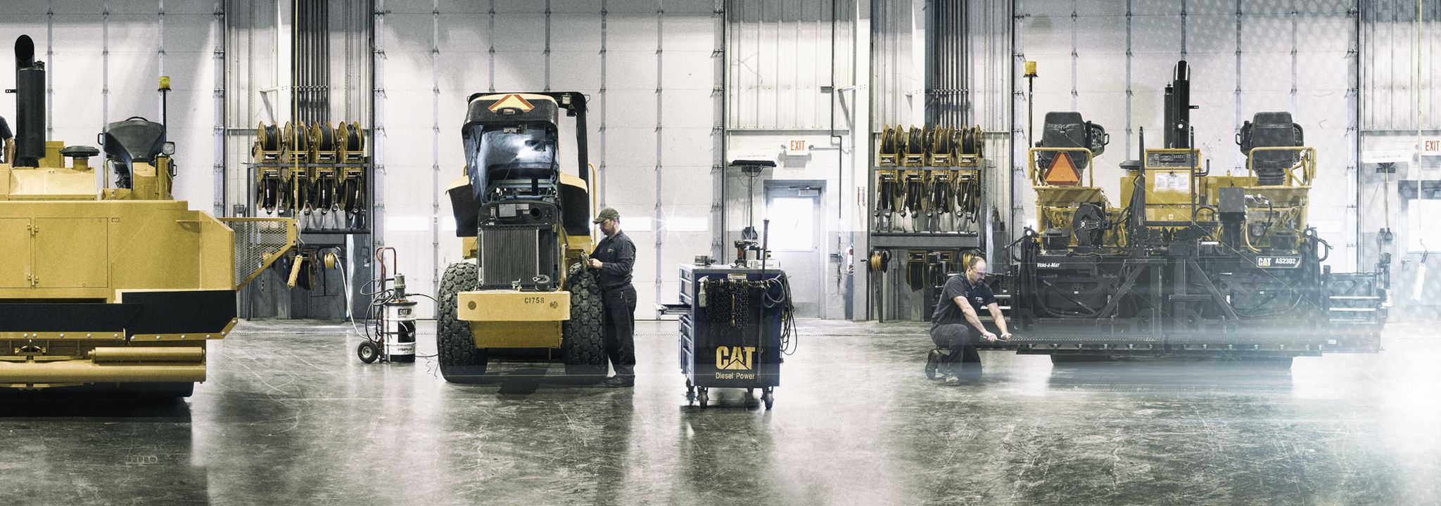 Person in warehouse inspecting Cat machine