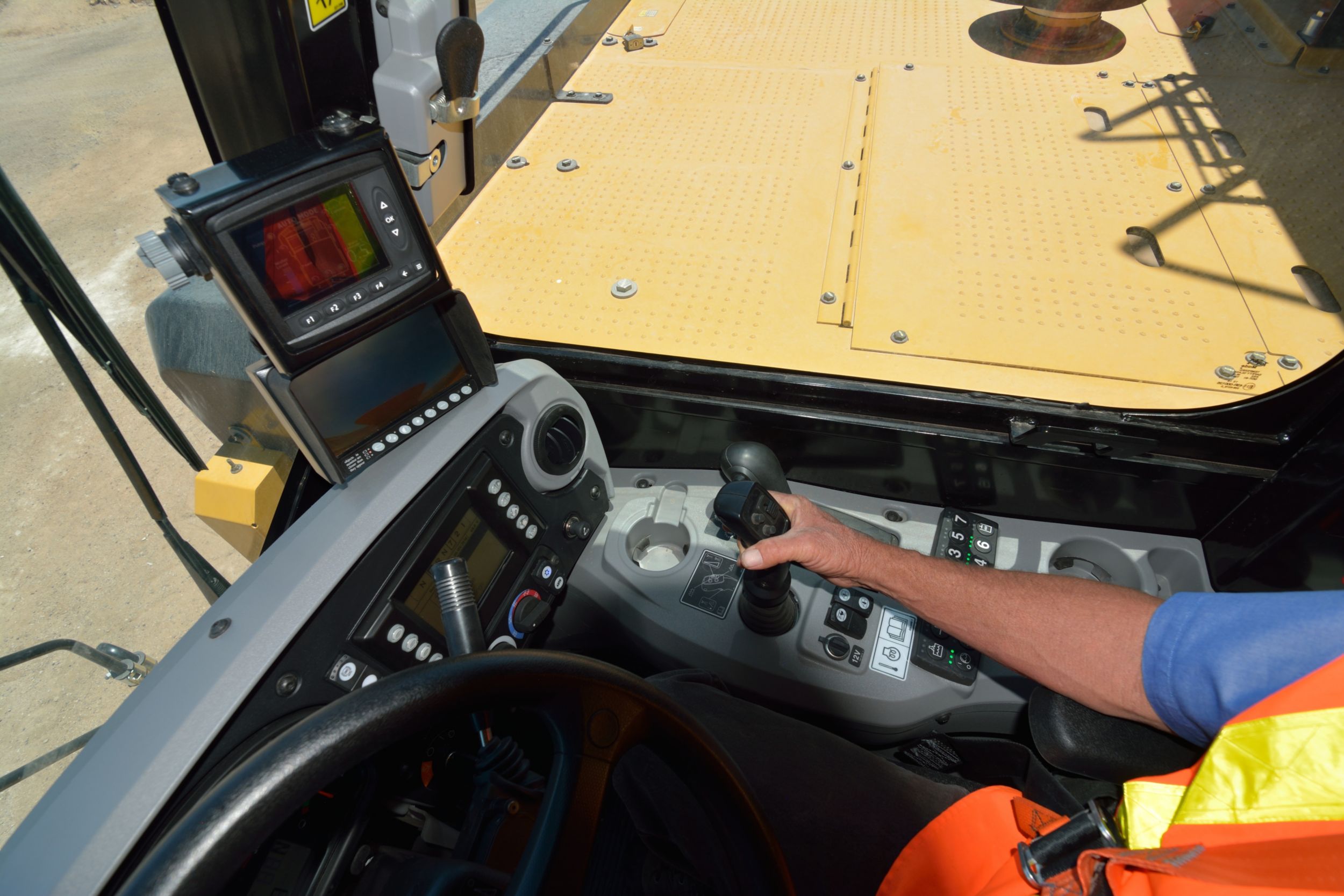 Operator using the Cat Water Delivery System integrated cab controls and electronics in a water truck at the Tuscon Proving Ground (TPG)>