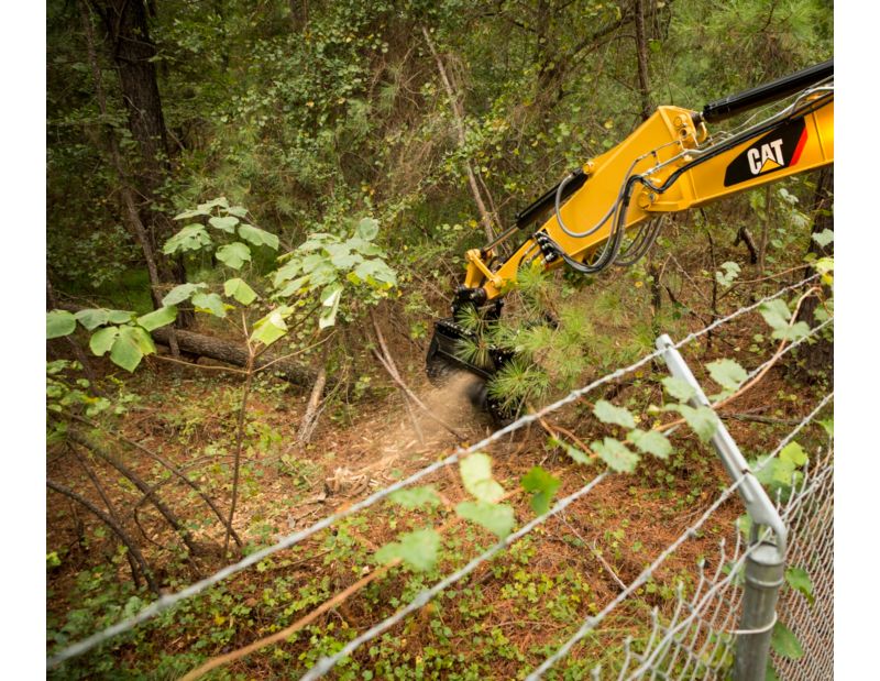 Cat® HM210 Mulcher Clearing Brush on Over a Fence