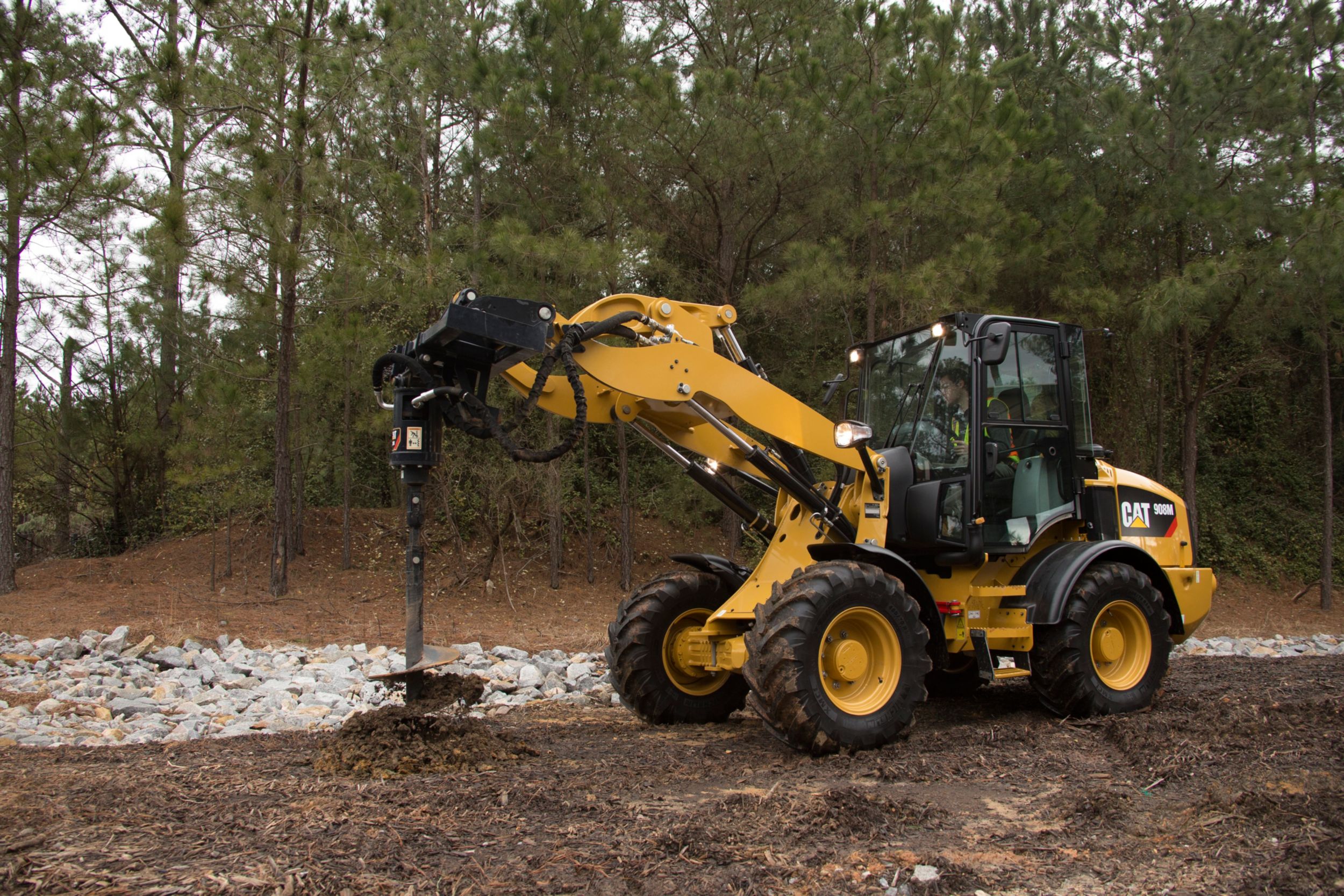 Tarière Cat® au travail sur une chargeuse sur pneus compacte 908M