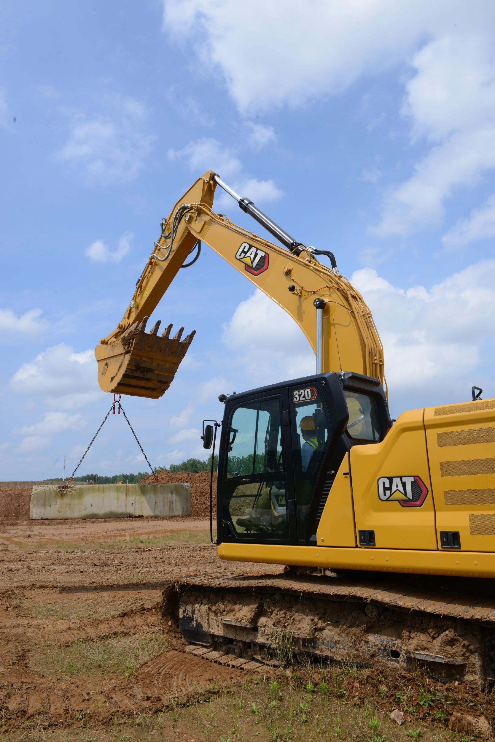 320 Excavator Moving a Concrete Barrier