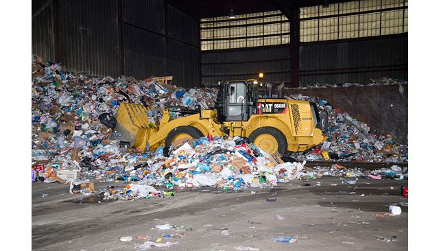 966M XE Waste Handler moving solid waste and saving fuel in a Transfer Station.