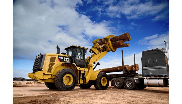 962M Logger with Cat Millyard Forks unloading a truck in a saw mill