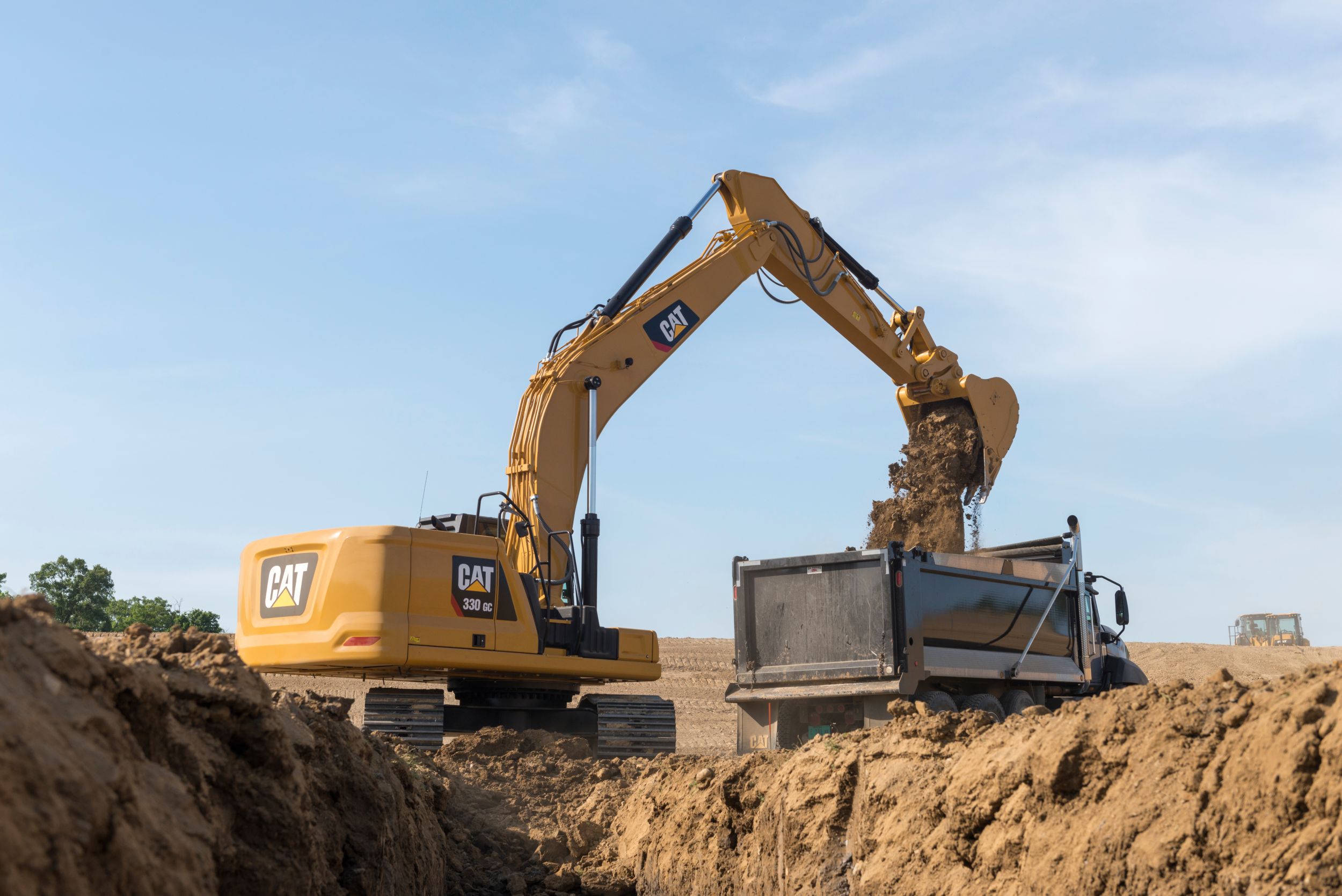 330 GC Excavating and dumping dirt into a truck