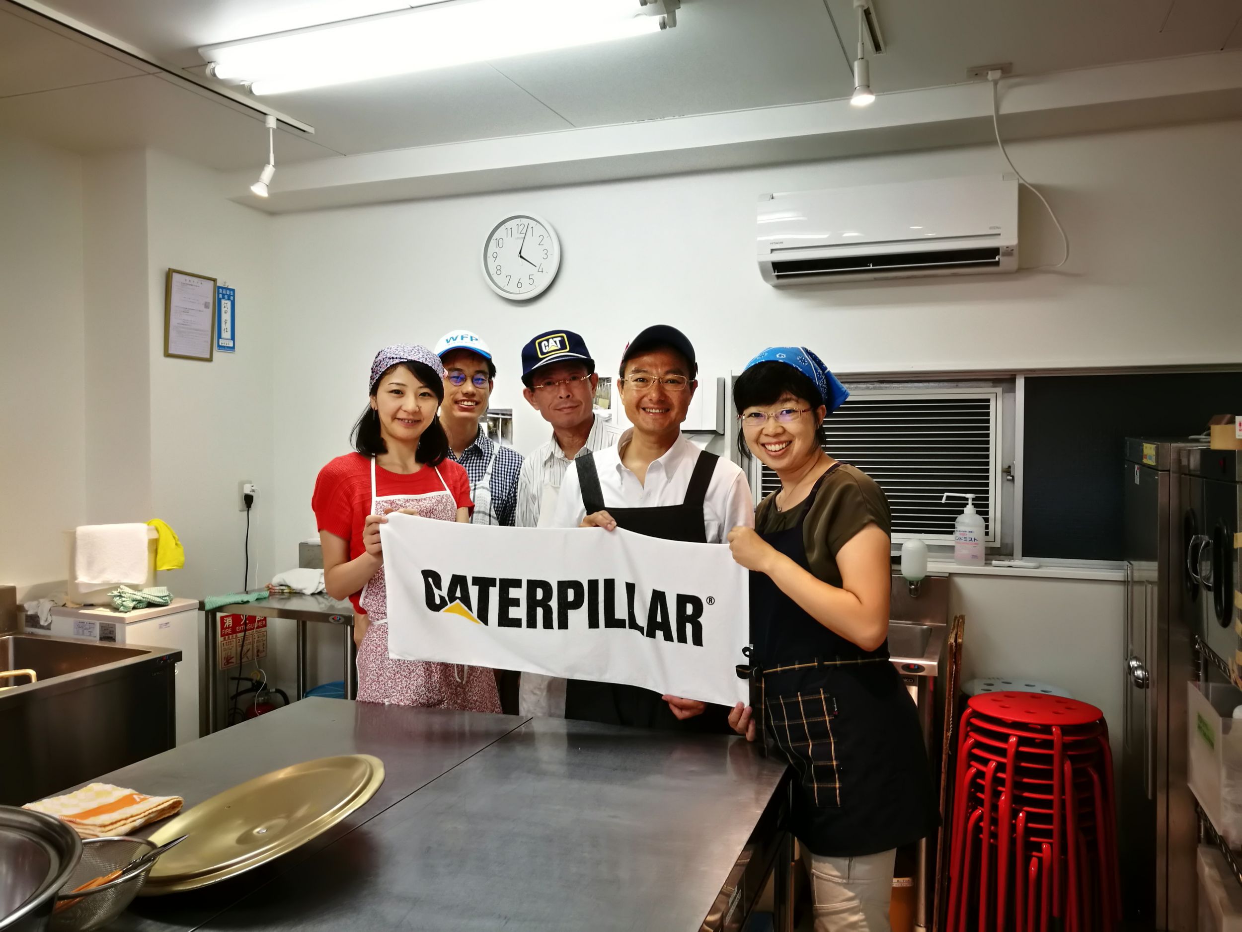 Employees with Caterpillar banner volunteering at food pantry