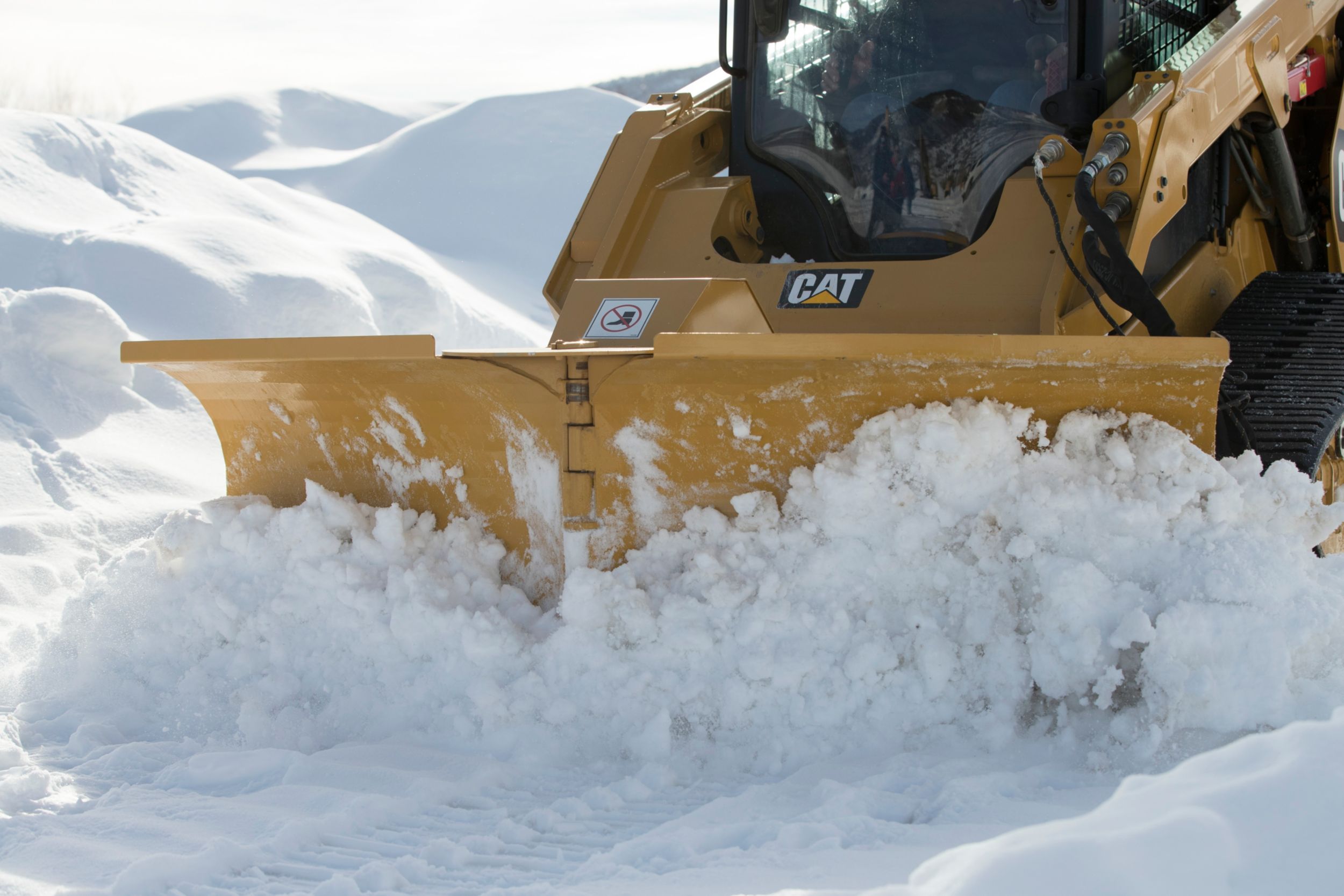 Chasse-neige en V multifonction Cat circulant dans la neige