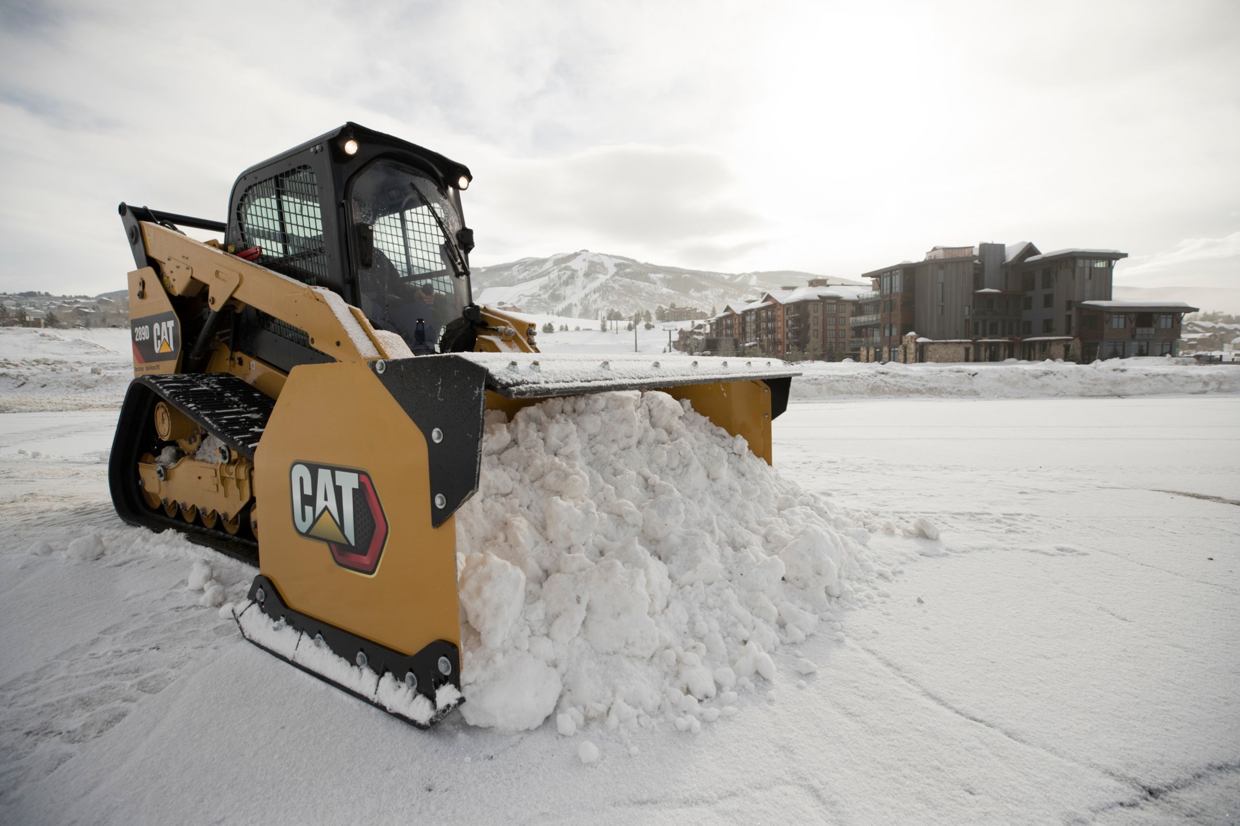 La Chargeuse à chaînes compacte 289D Cat® et un chasse-neige au travail dans le Colorado.