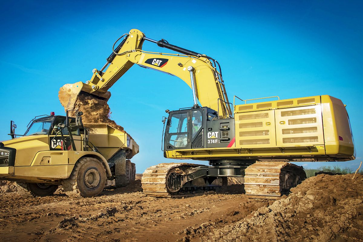 374F Çok Ağır Hizmet Tipi Kovayla belden kırmalı bir kamyona yükleme yapıyor