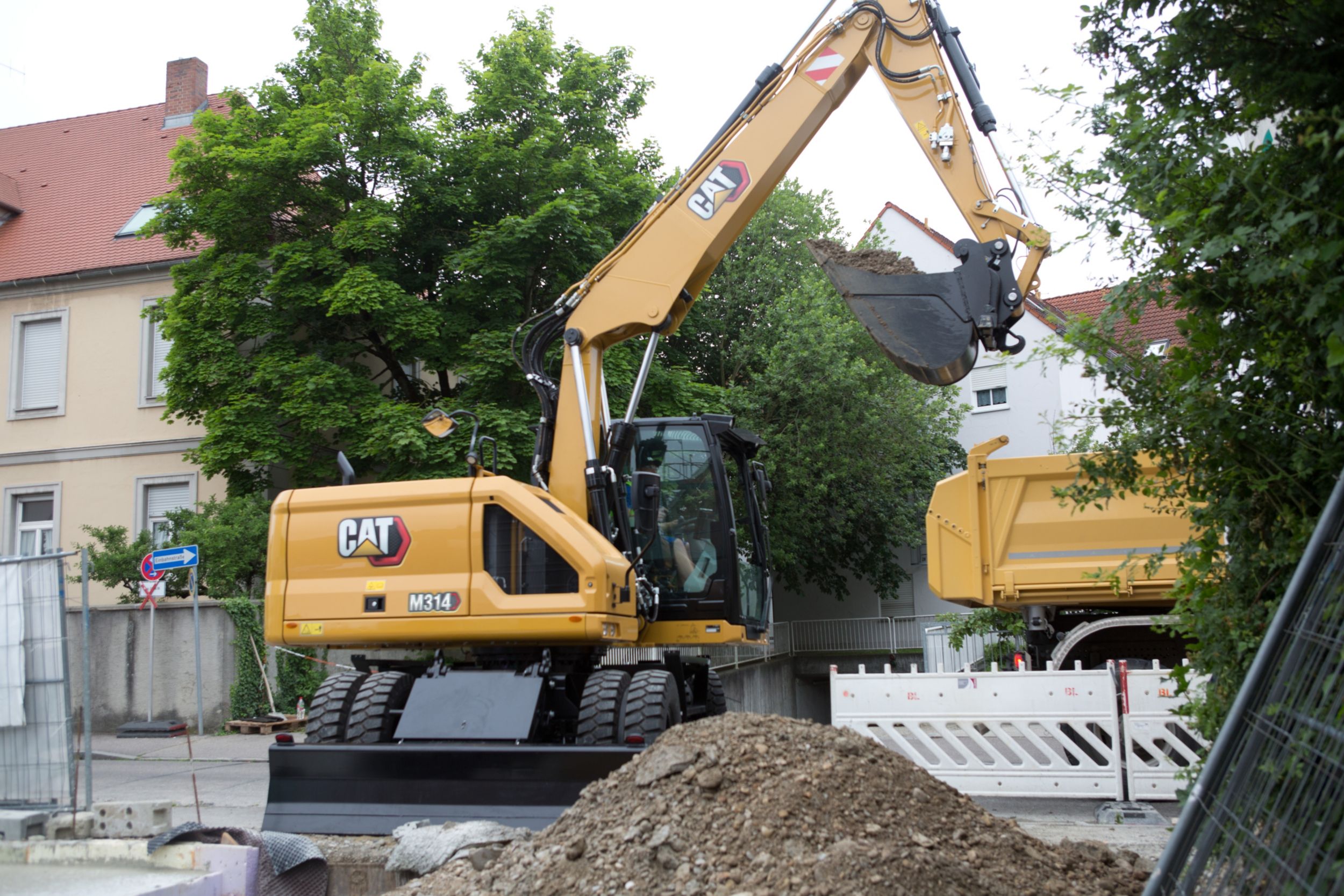 M314 Wheeled Excavator unloading truck to backfill