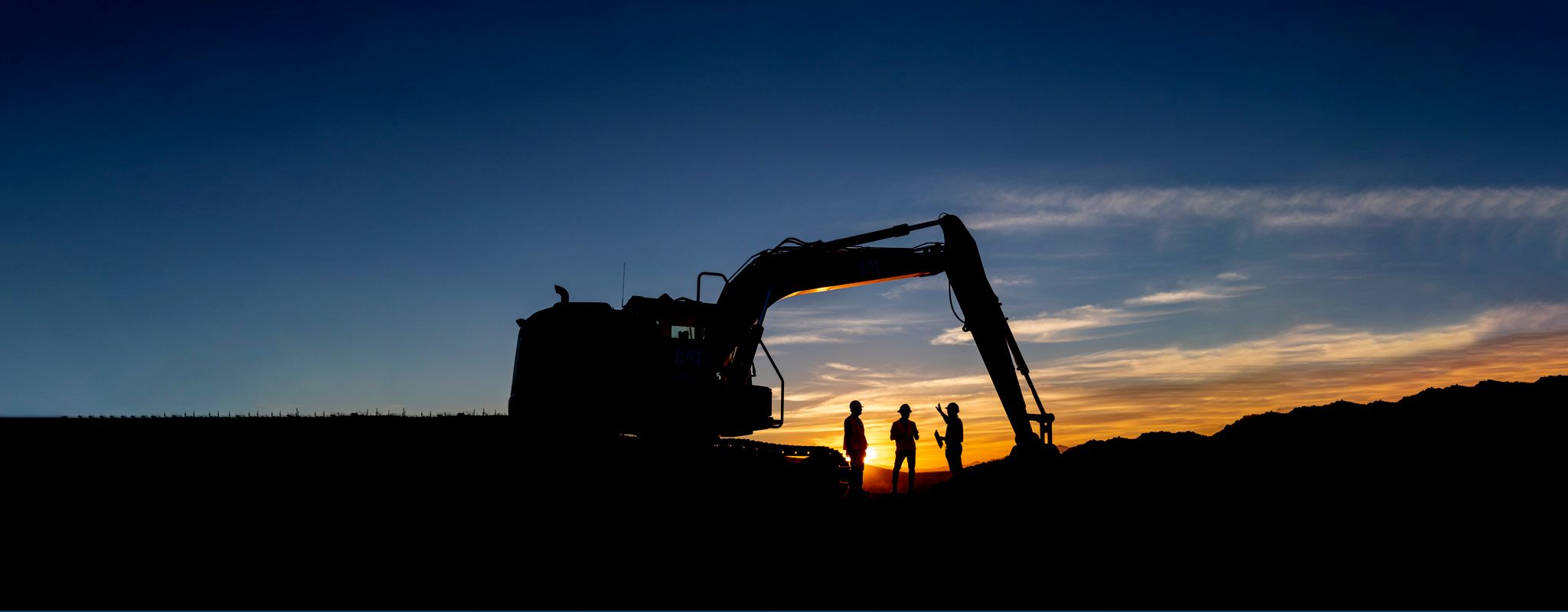 Silhouette of a Cat machine in front of a sunset