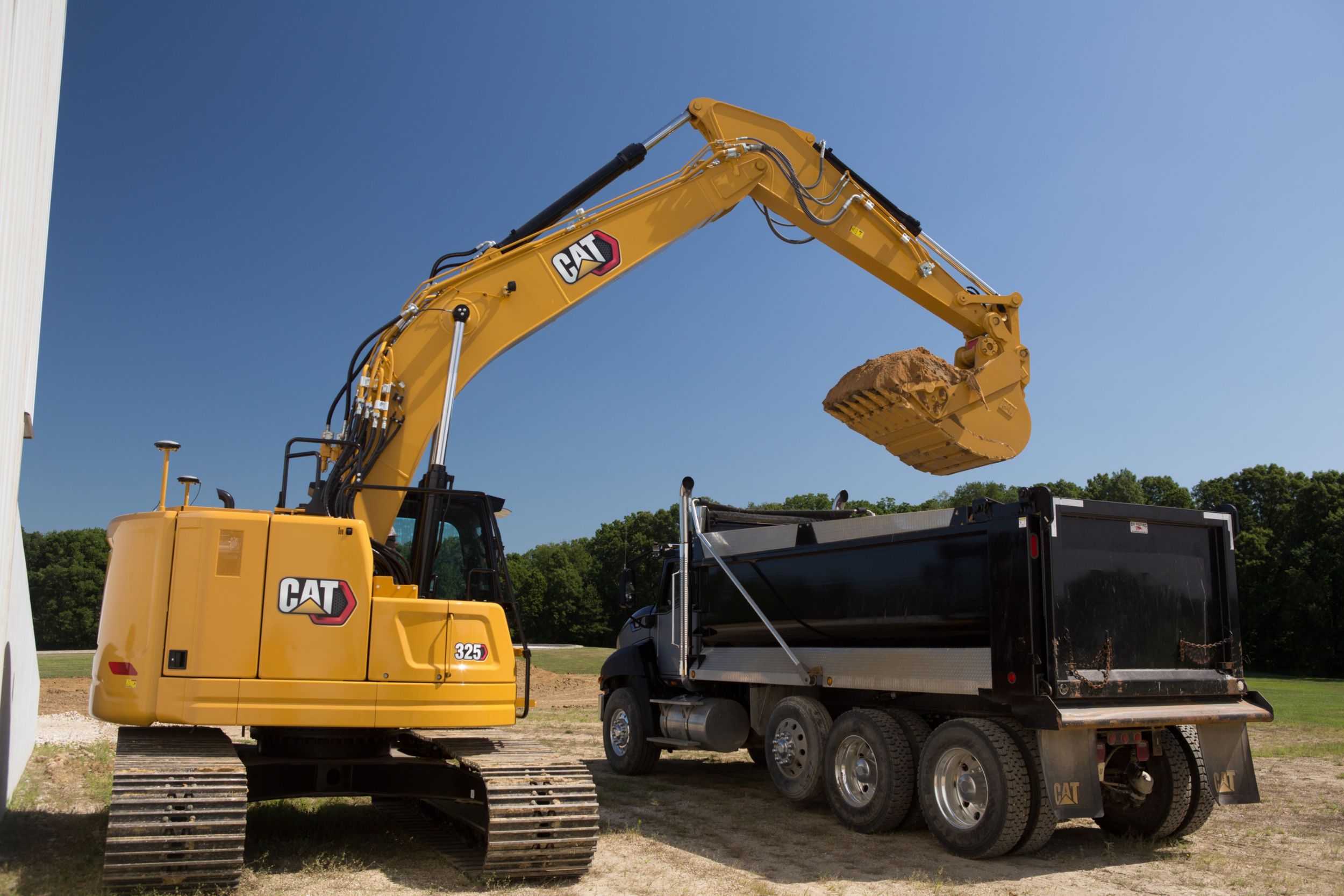 Hydraulische graafmachine 325 die een dumptruck laadt