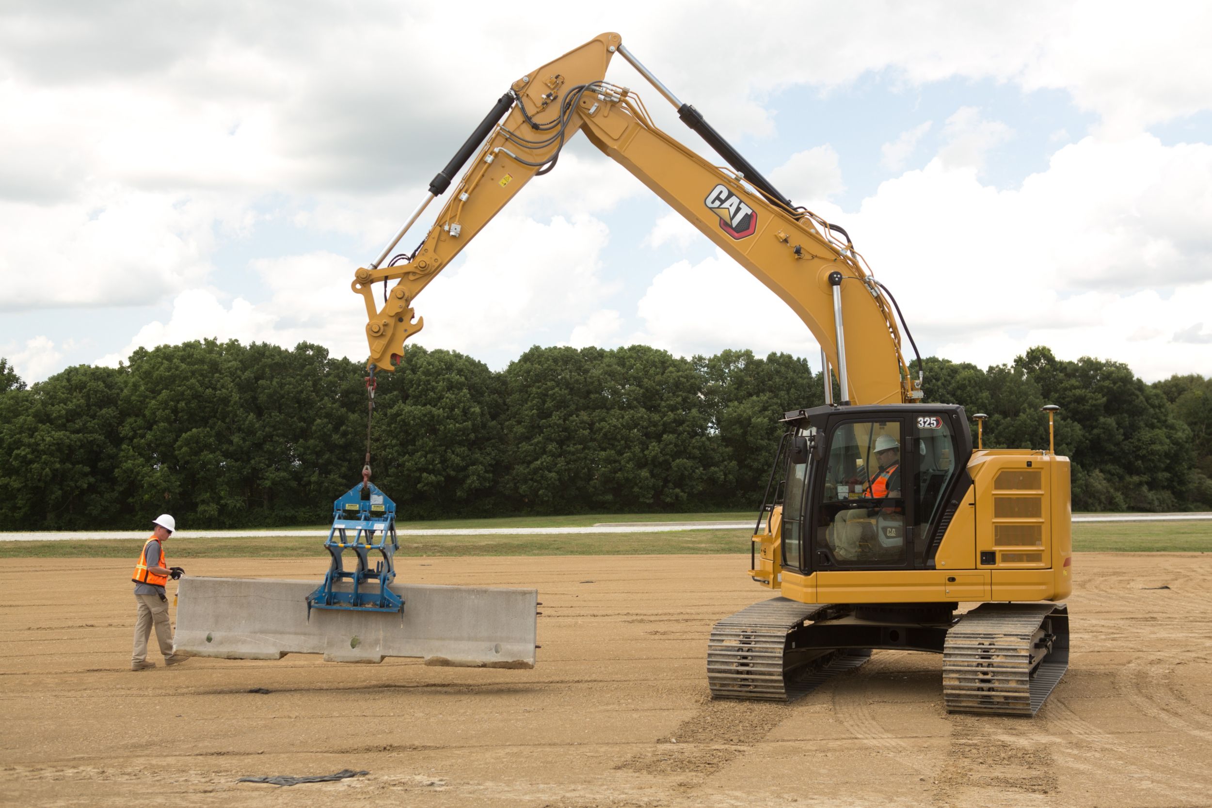 325 Hydraulic Excavator lifting a concrete barrier