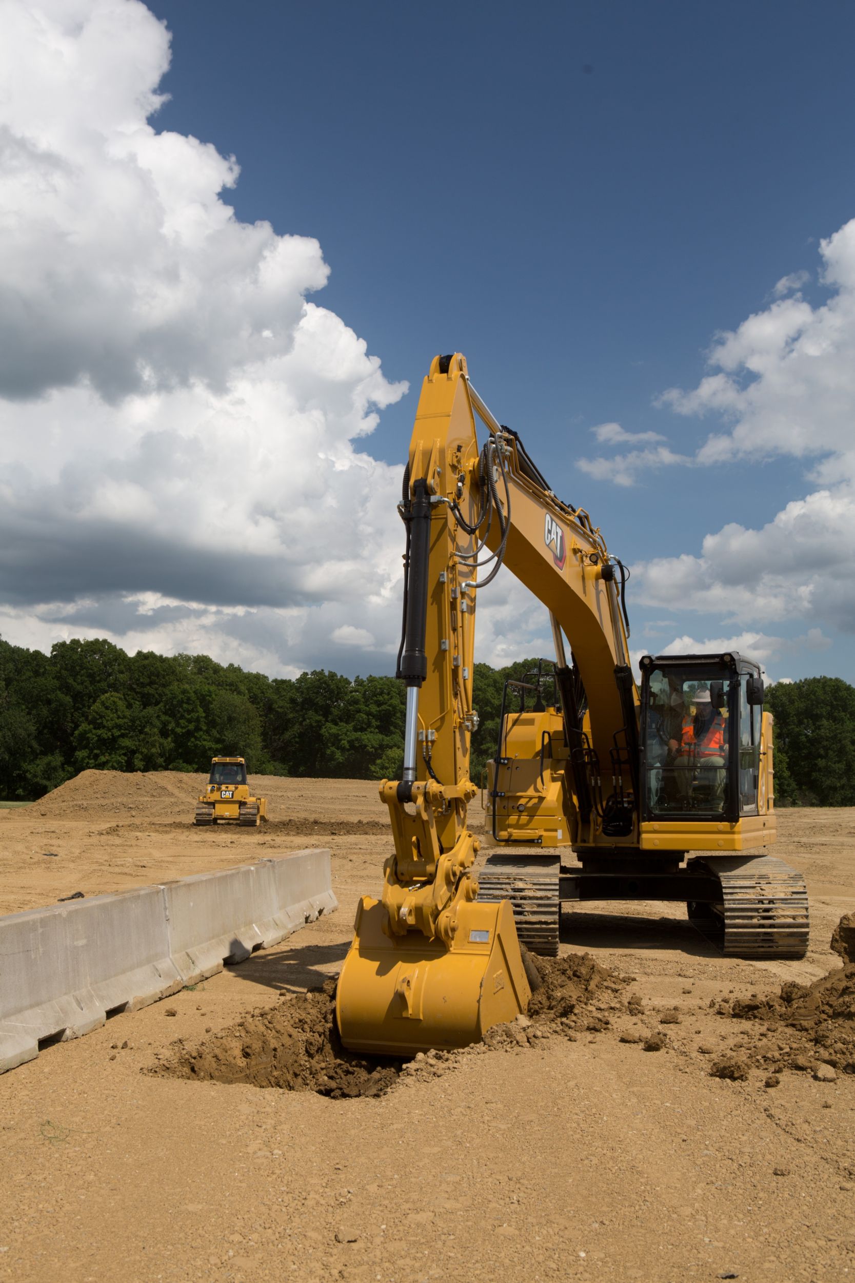 325 Hydraulic Excavator digging near a barrier