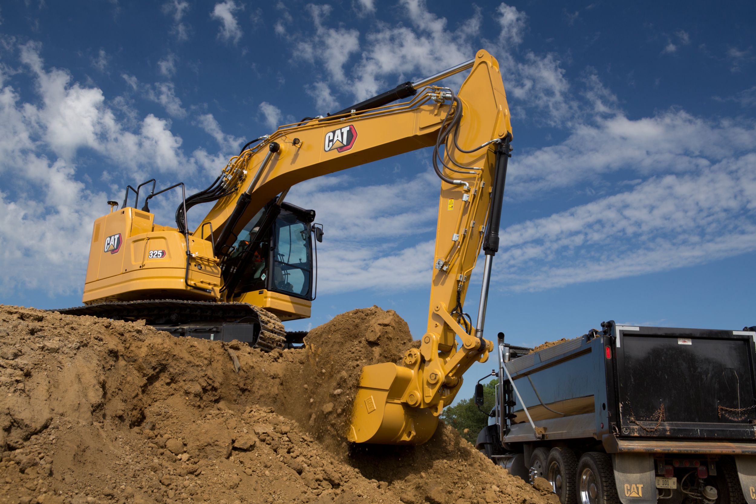 325 Track Excavator loading dirt into a dump truck