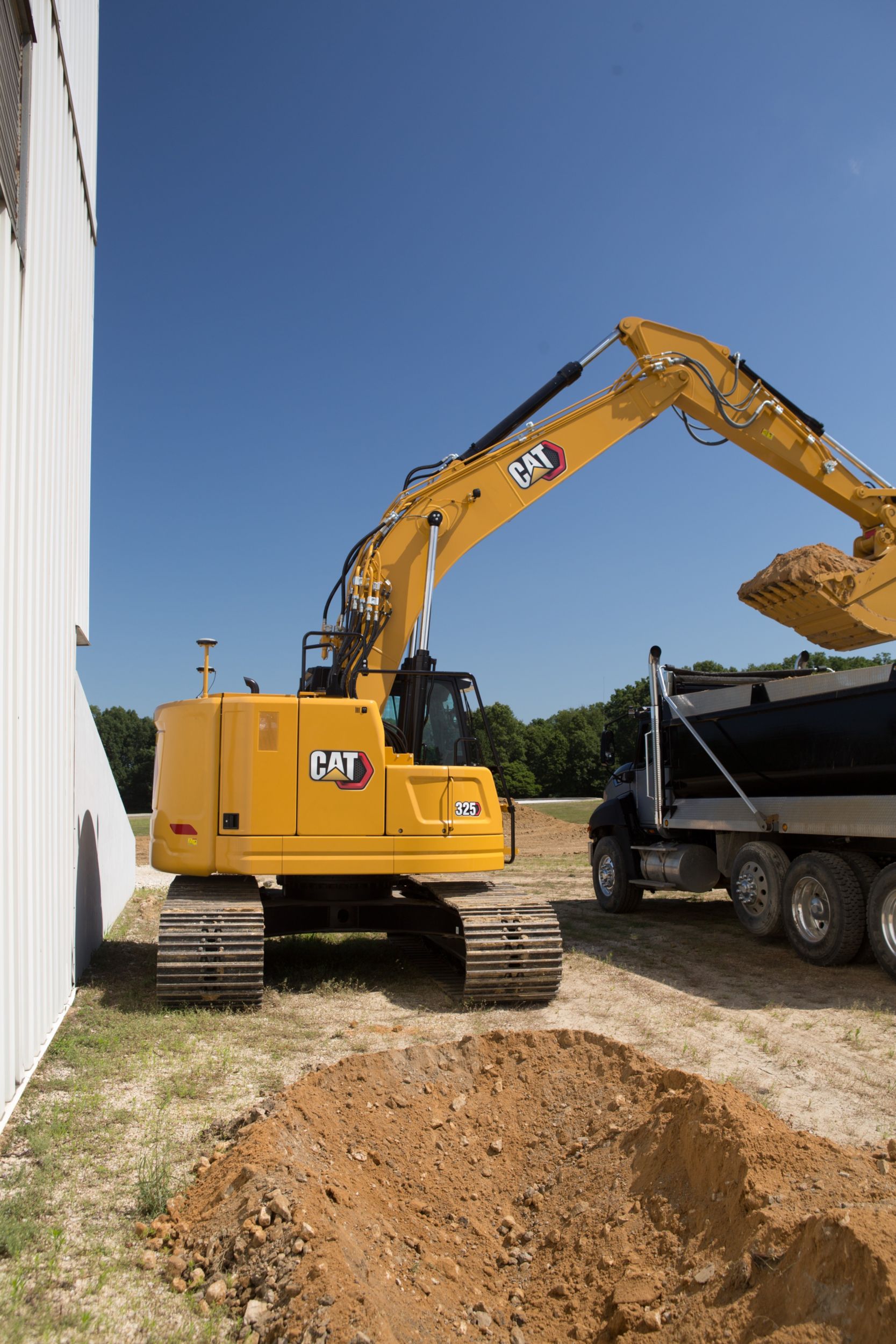 325 Hydraulic Excavator digging near a wall