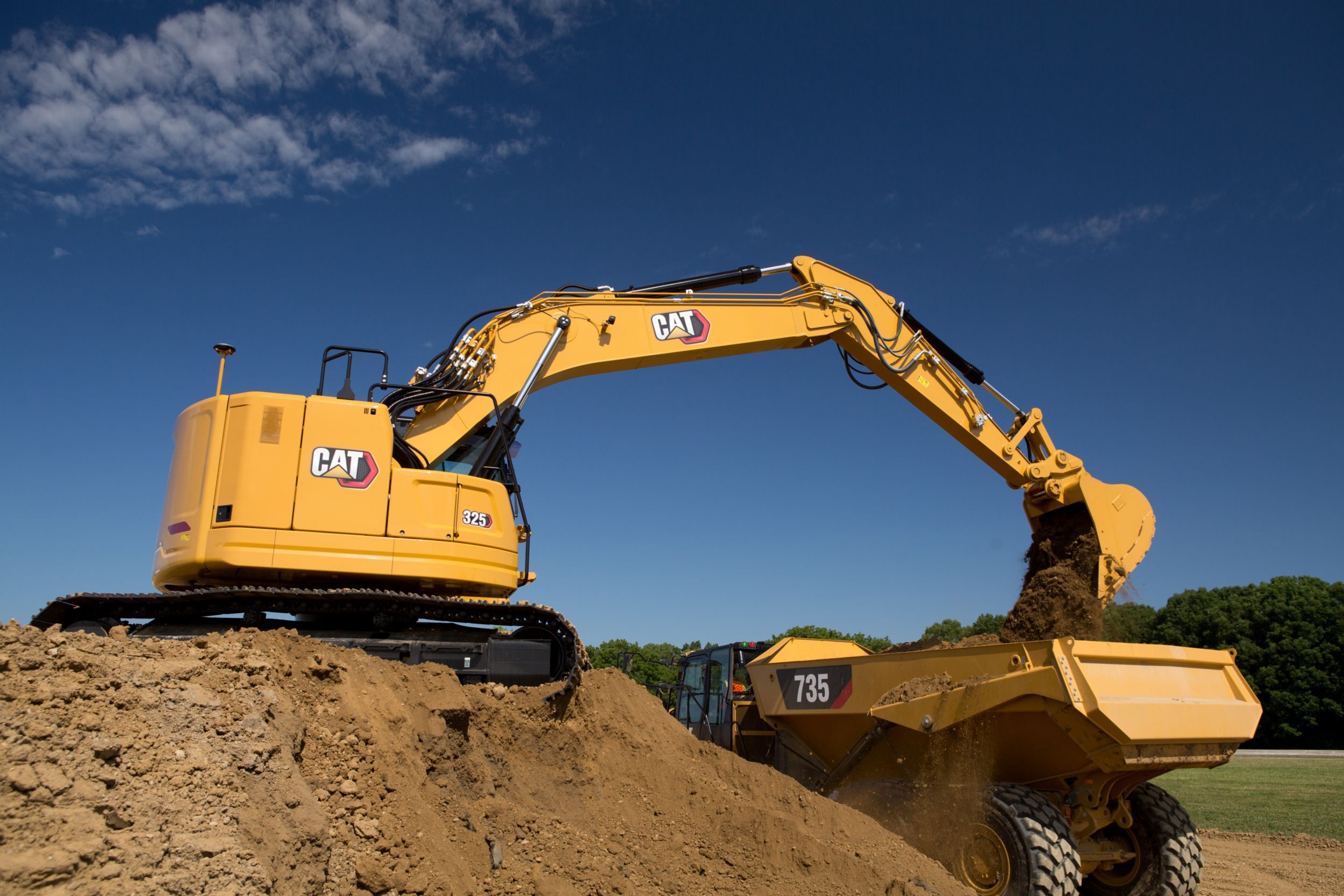 Koparka hydrauliczna 325 ładująca ziemię na wozidło przegubowe