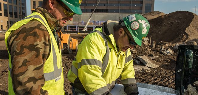 Two workers looking at plans