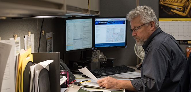 Man Looking at Paperwork at his desk