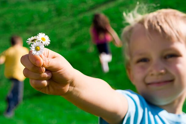 Braço de uma criança segurando flores