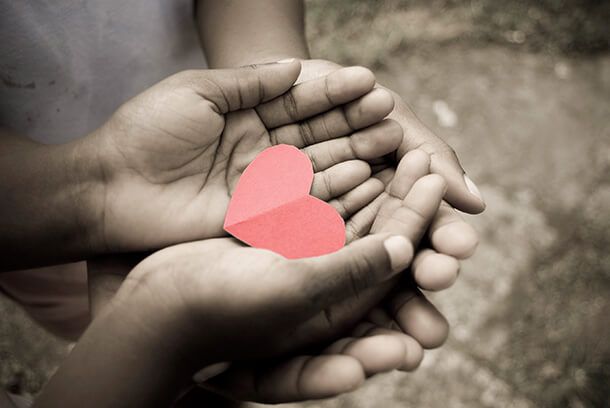 Mãos segurando um coração de papel
