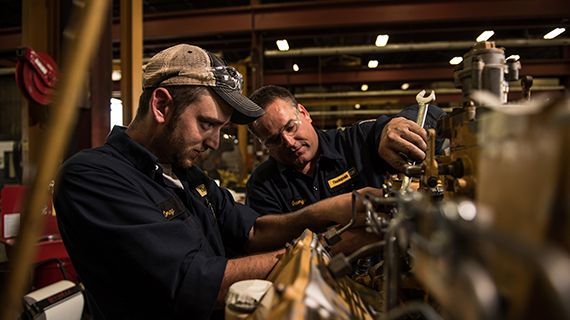 Technicians servicing engine