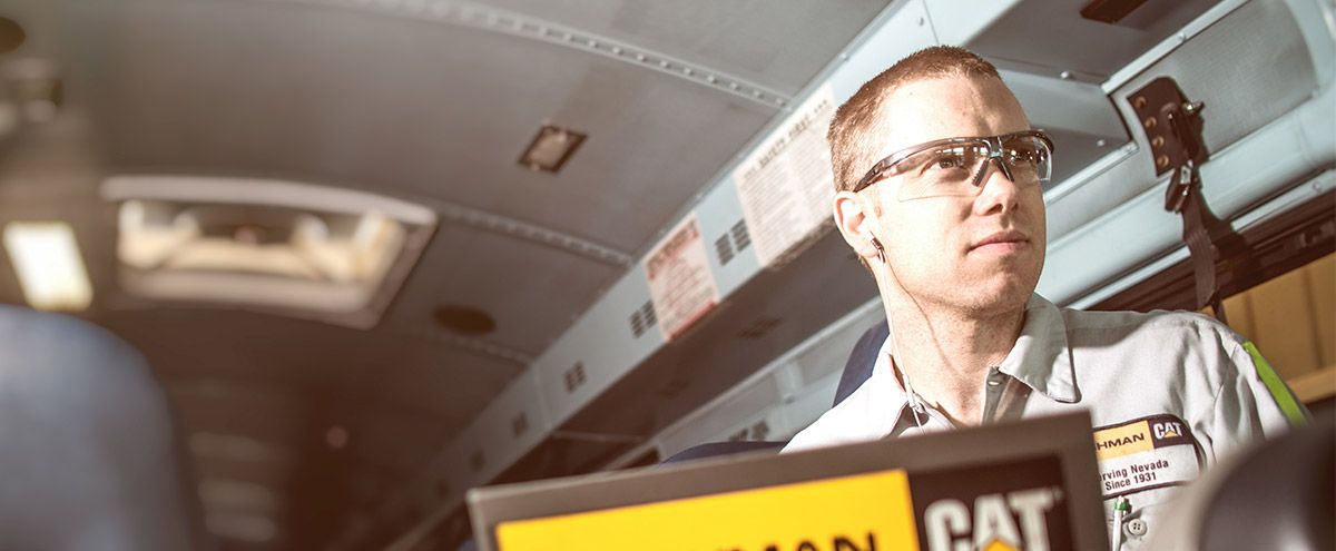 Cat dealer tech using computer to trouble shoot equipment issue