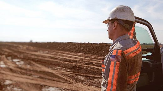 Customer looking towards his equipment on a jobsite during the COVID-19 pandemic